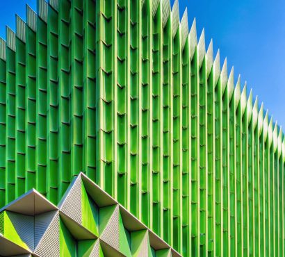 green-building-with-abstract-geometric-pattern-shading-fins-concrete-house-wall-surface-against-blue-sky-modern-home-exterior-architecture-background-vertical-frame (1)